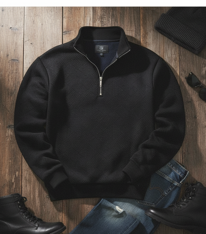 Black quarter-zip sweater on a wooden surface with jeans and boots.